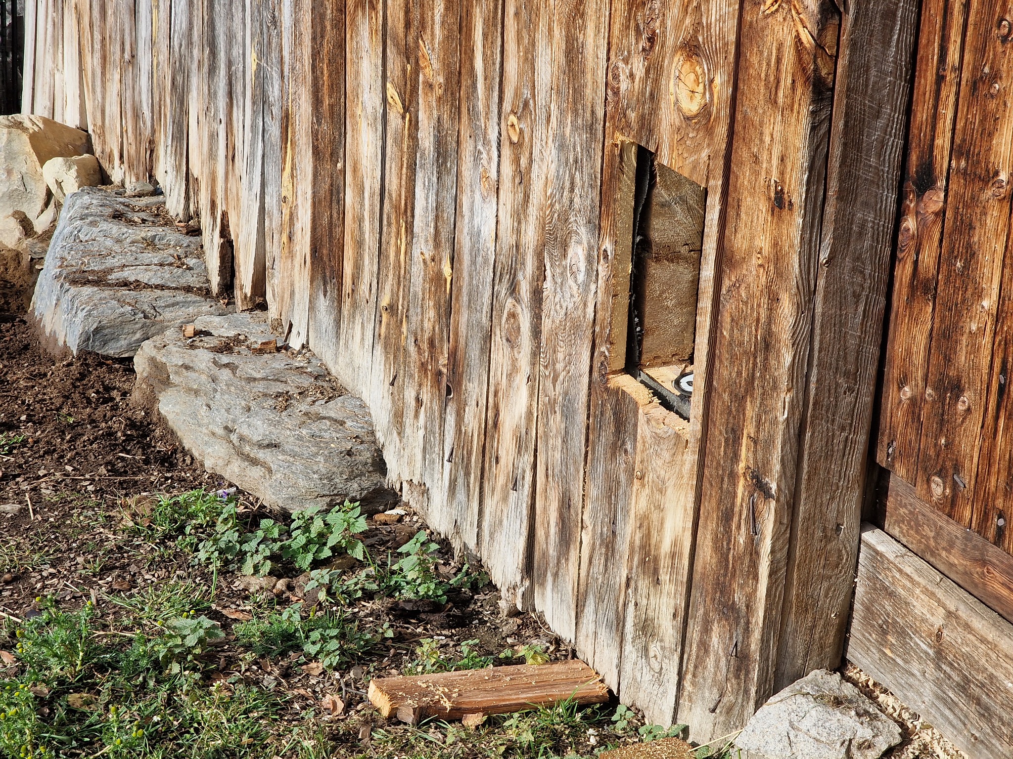 The new opening seen from outside the old barn wall, with a stone wall and grass in front.