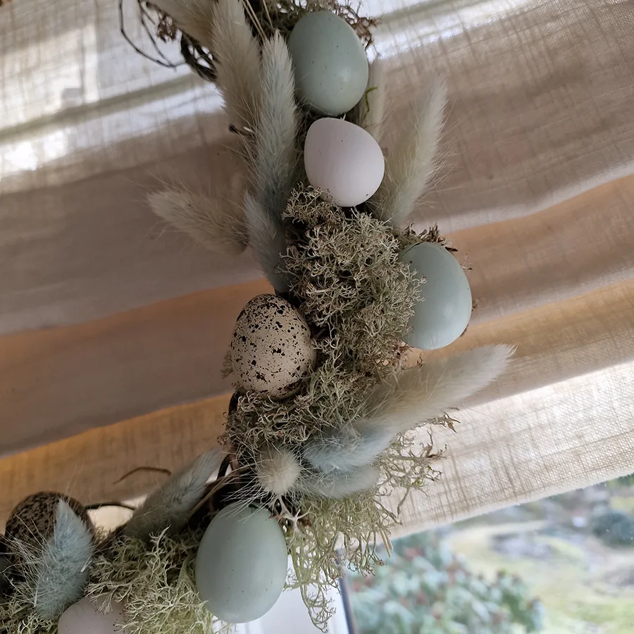 Quail eggs in different colours on an Easter wreath